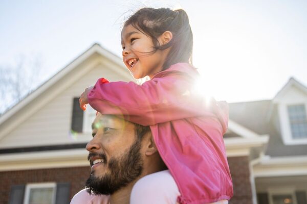 A happy father and his daughter around a real estate property