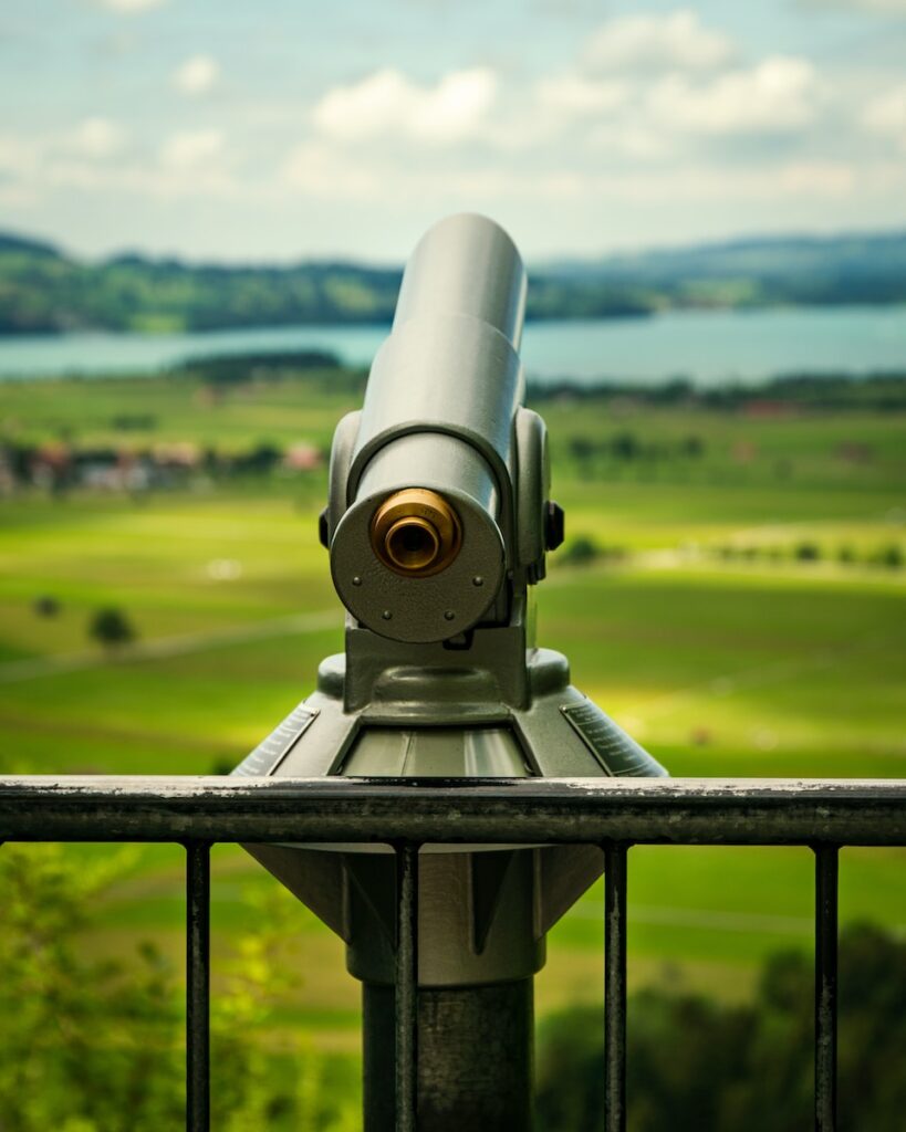 gray and black telescope on green grass field during daytime